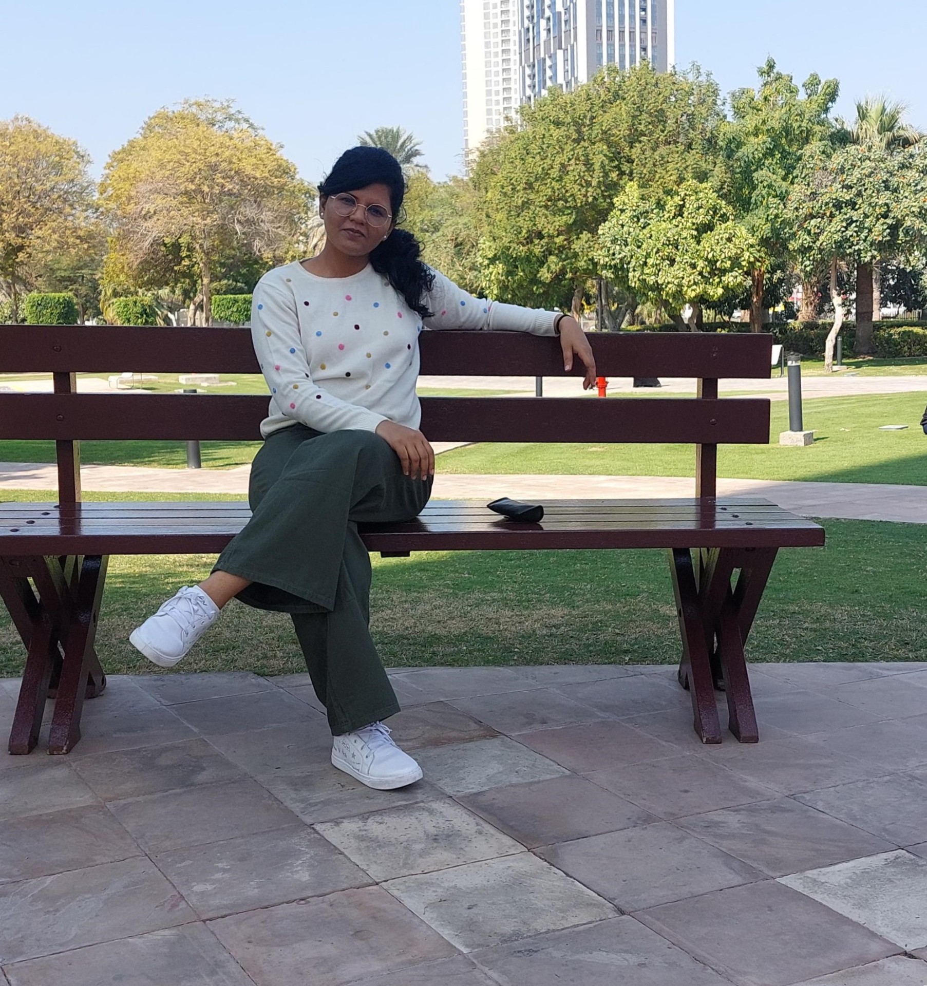 32°N UX designer relaxing at a park bench in Dubai