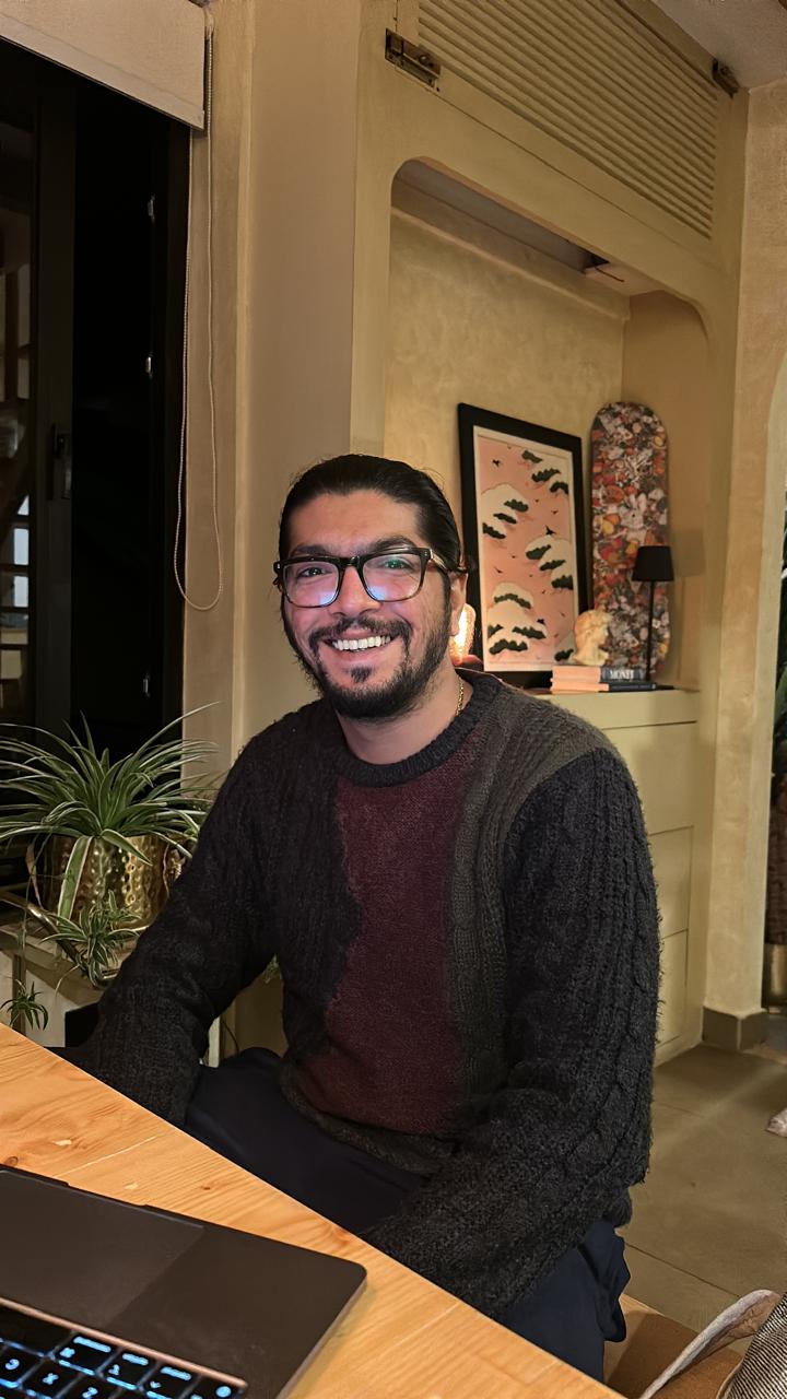 32°N team member smiling at a cozy café with a laptop