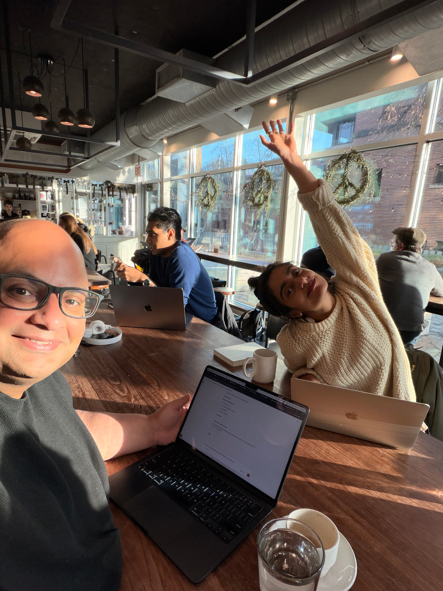 Enterprise UX designers collaborating at a café with laptops